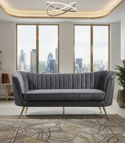 Modern grey velvet 3 seater sofa with curved channel tufted back and gold metal legs in luxury living room UAE with city view