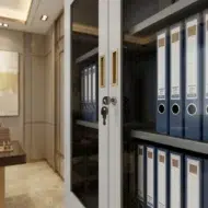 Elgraviax steel storage cabinet for office furniture with sliding glass doors, lower lockable storage, and light grey steel finish in a modern UAE office.